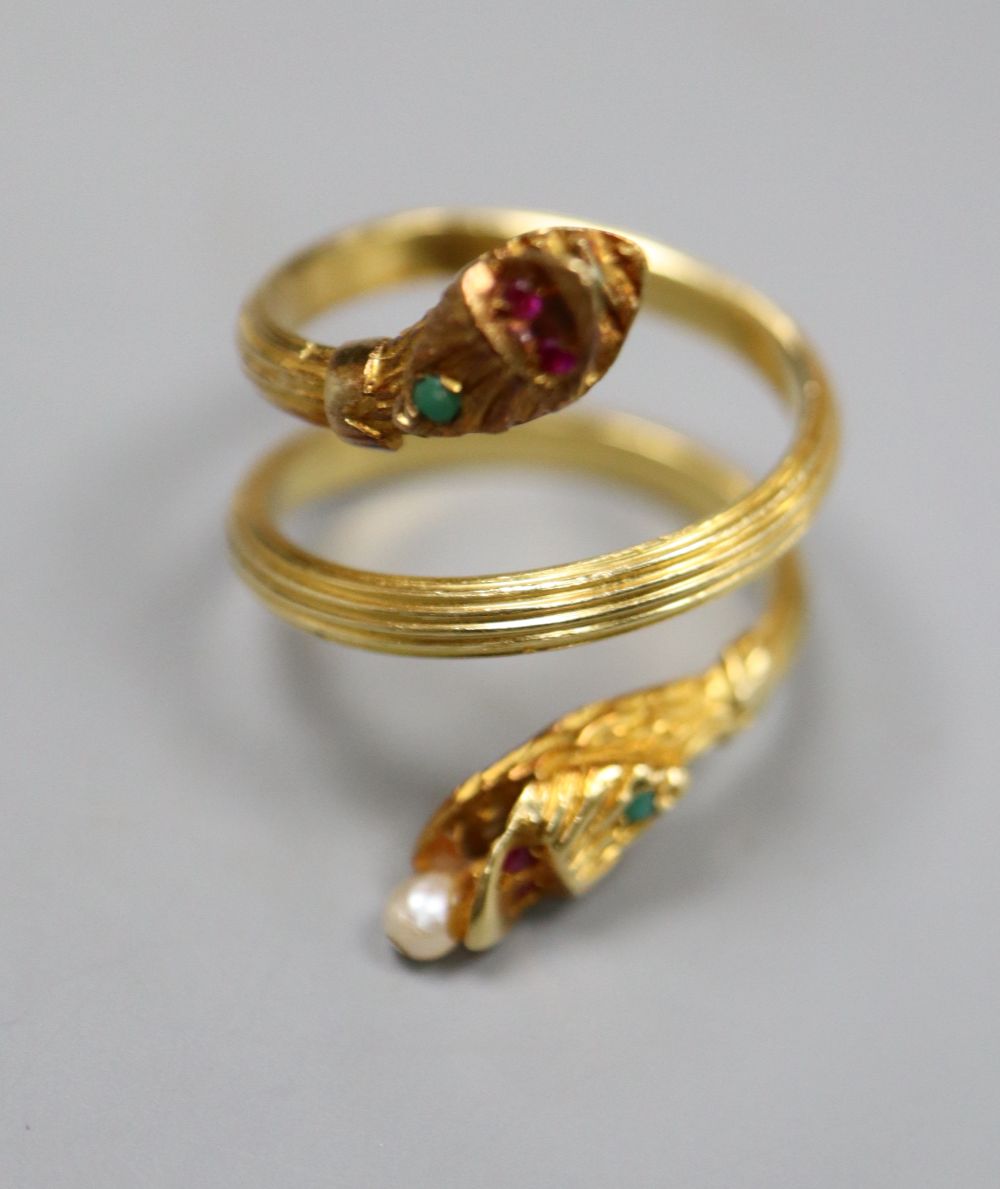 A Georgian style reeded yellow metal and gem set twin headed serpent ring,